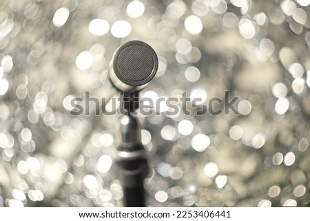 Podcasting concept, vintage recording microphone on swirly bubble bokeh balls in the background, close up with selective focus