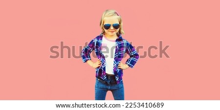 Portrait of stylish little girl child model posing on pink background