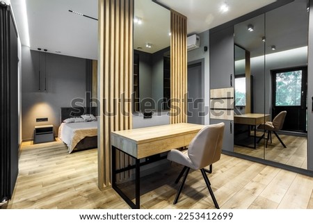 Modern luxury bedroom in loft style with dark and grey style. Dark headboard and wooden floor with wall panel Royalty-Free Stock Photo #2253412699