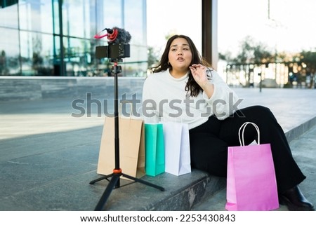 Attractive latin woman influencer filming a video blog going shopping and making a product review 