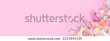 Cute pink sweet baking flat lay for Easter holiday. Cooking background with baking ingredients, rolling pin, whisk for whipping, cookie and cutters, sugar sprinkling, flour, top view copy space 