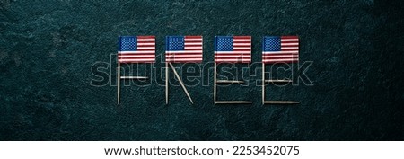 some american flags forming the word free with their poles on a dark gray textured background, in a panoramic format to use as web banner or header