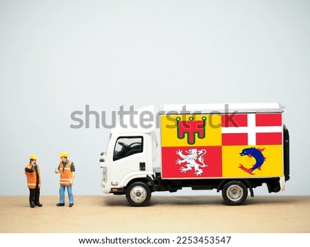 Mini toy at table with white background. Industrial shipping concept. Auvergne-Rhône-Alpes flag design, is a region in southeast-central France created by the 2014 territorial reform of French region.