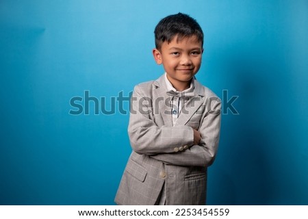 the studio shot isolated image of the boy wearing suit with the blue backdrop