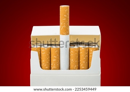 Close up of open pack of cigarettes on red background Royalty-Free Stock Photo #2253459449