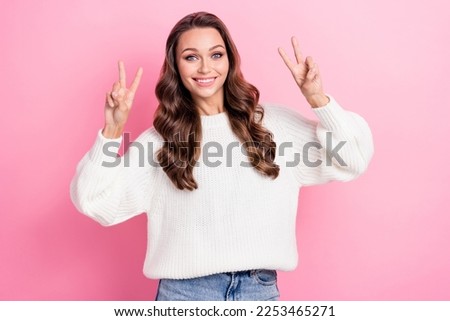 Photo of adorable overjoyed girl beaming smile demonstrate v-sign isolated on pink color background
