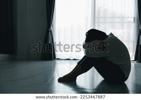 Concept of sad teenage girl depression. Upset teenage girl sitting at floor indoors. Anxiety young woman Despair and stress. Lonely and unhappy female are social victims. loneliness youth in home. Royalty-Free Stock Photo #2253467887