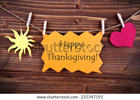 Happy Thanksgiving Greetings on a Orange Label on a Line with a Sun and a Heart, on Wood, Thanksgiving Background