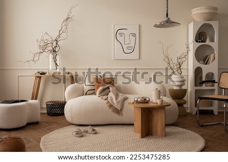 Warm and cozy composition of living room interior with mock up poster frame, modular sofa, wooden coffee table, round rug, beige wall, modern rack and personal accessories. Home decor. Template.  Royalty-Free Stock Photo #2253475285
