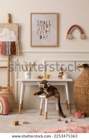 Cozy composition of kids room interior with mock up poster frame, white desk, animal wicker basket, plush monkey toys, rainbow ornament, wooden blocks and personal accessories. Home decor. Template.