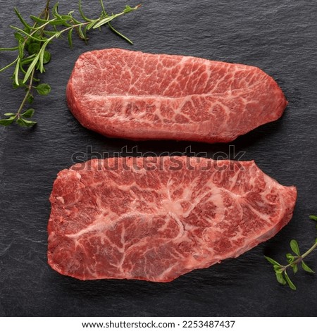 Top Blade beef steaks on black background. Fresh raw meat. Top view.