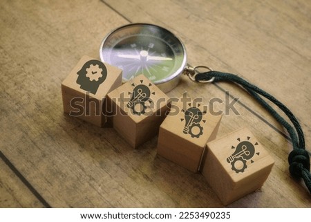 Selective focus image of compass and icon of idea or generate idea on a wooden cube 