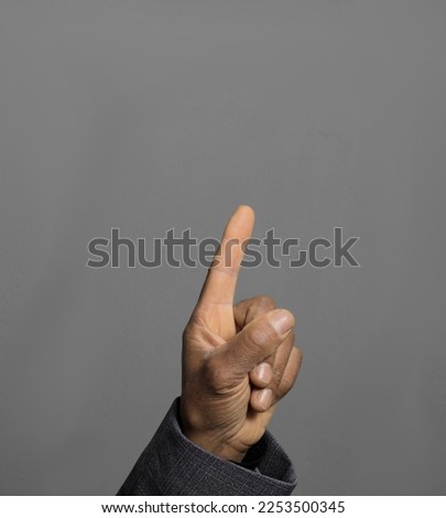 pointing his finger up on grey background with people stock photo	 