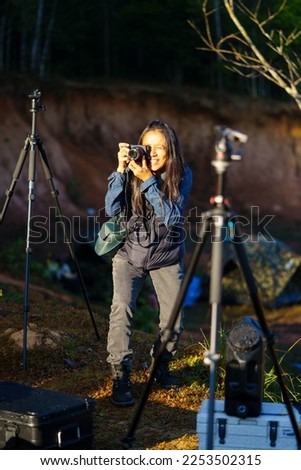 Asian traveler woman take a photo inside tent in camping ground on the morning time at Khao Yai, Nakhon Ratchasima province, Thailand.