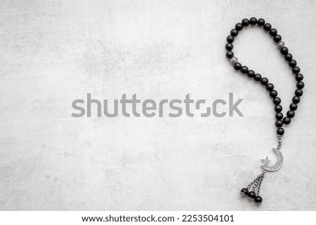 Islamic background with Muslim rosary and silver crescent moon Royalty-Free Stock Photo #2253504101