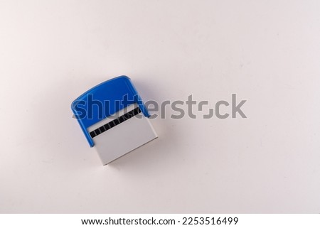 Selective focus top view of rubber stamp isolated on white background with empty text area. Royalty-Free Stock Photo #2253516499