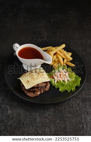 Double decker burger and fries on white plate