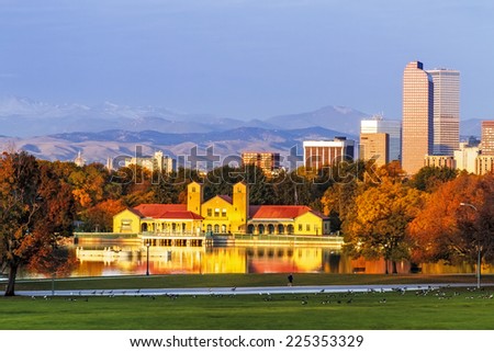 Denver Colorado skyline from City Park with City Park Boathouse and Rocky Mountains in background on autumn morning