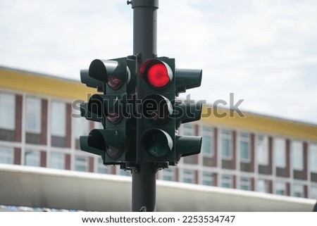A closeup shot of a traffic light showing a red stoplight in the street
