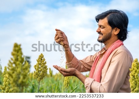 Happy smiling seeing seeds from recently grown crop at farmland showing with copy space - concept harvested or successful cultivation and prosperity Royalty-Free Stock Photo #2253537233
