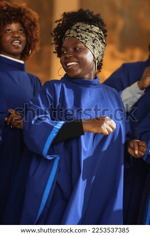 Black Christian Female Gospel Singer Singing, Happy to be Spreading the Love of Lord Jesus Christ. Cheerful African American Woman in Blue Robe in Sunday Church with Music Bringing Peace, Hope, Love