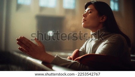 Young Christian Woman Sits Piously in Majestic Church, with Folded Hands She Seeks Guidance From Faith and Spirituality while Praying. Religious Belief in Power and Love of God Royalty-Free Stock Photo #2253542767
