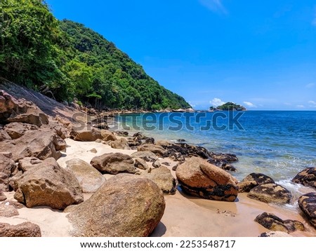 View of the beach with rocks and island in the background.