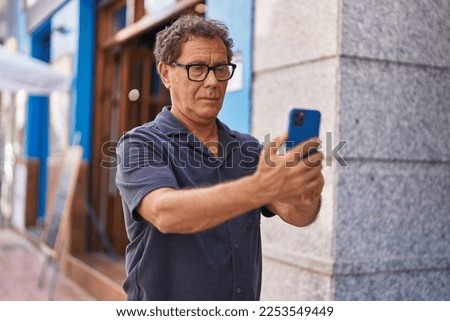 Middle age man making selfie by the smartphone at street