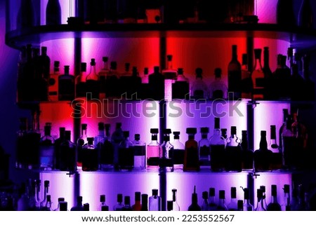A lot of alcohol bottles in a modern bar. Pub background with drink silhouettes