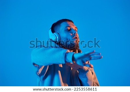 man with headphones in sweatshirt enjoying favorite music