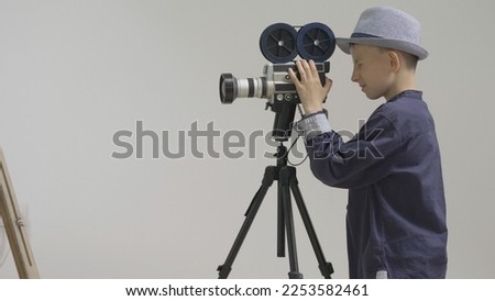 Young boy look on video camera, director stage child thumb up