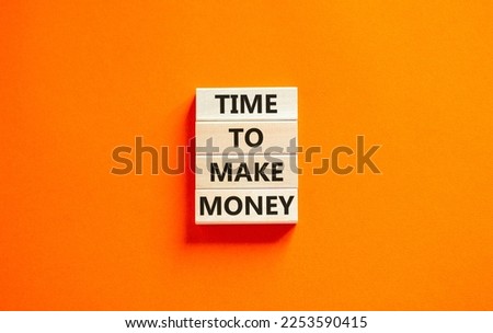 Time to make money symbol. Concept words Time to make money on wooden blocks on a beautiful orange table orange background. Business, finacial and time to make money concept. Royalty-Free Stock Photo #2253590415