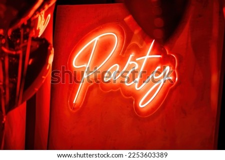 Beautiful place for st valentines holiday with neon letters party design element inside. Logo signage text of color led lamp shine sign light on wall at muffled glamour night room background