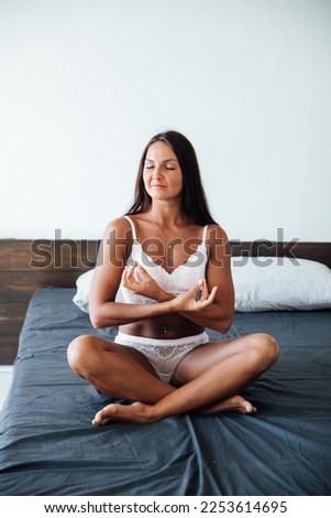 woman on the bed sitting meditation asana relax rest attention on yourself