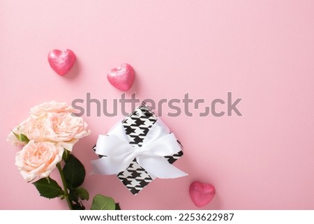 A mock-up of a Valentine's Day banner with a gift box, heart-shaped candies and a bouquet of roses on a pink background. Valentine's Day greeting card template. Copy space. Flat lay, top view.