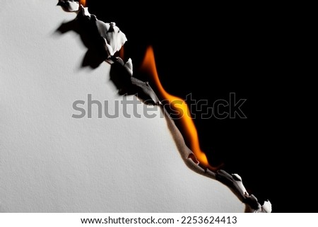 Burning paper on black background. Burnt paper edges. Royalty-Free Stock Photo #2253624413