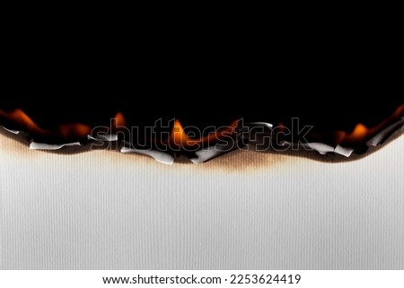 Burning paper on black background. Burnt paper edges. Royalty-Free Stock Photo #2253624419