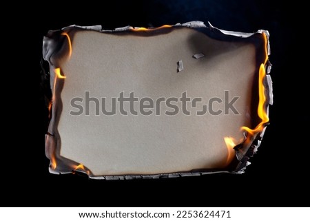 Burning paper on black background. Burnt paper edges. Royalty-Free Stock Photo #2253624471