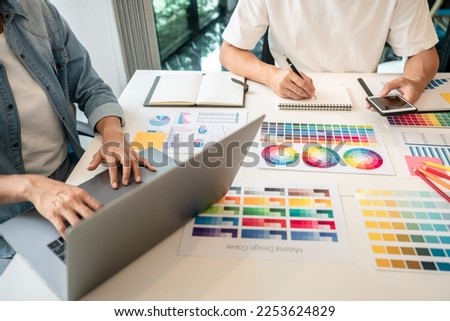 Two creative graphic designer team working on color selection and drawing on graphic tablet, Color swatch samples chart for selection coloring in inspiration to creativity at workplace.