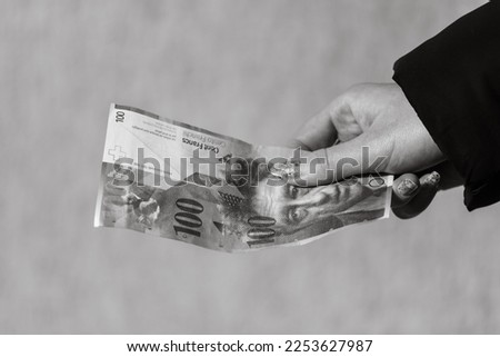 World money concept, close up of 100 swiss franc banknote, photo of CHF currency isolated. Hand holding money, swiss franc.