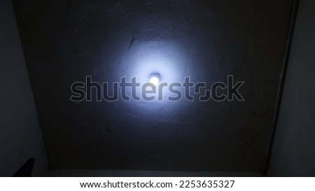 The white lamp bulb is lighting on dark of top surface texture