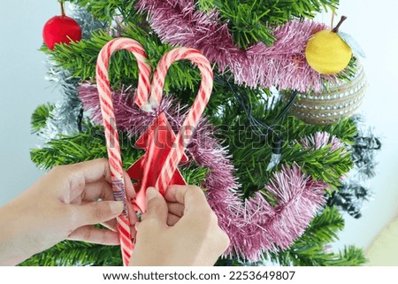 Christmas candy cane in a heart shape with christmas tree.