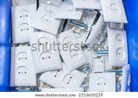 Many new white electric sockets, outlets in box at fabric, plant - top down view. Production, power, manufacturing, energy, electricity and tecnology concept Royalty-Free Stock Photo #2253650229