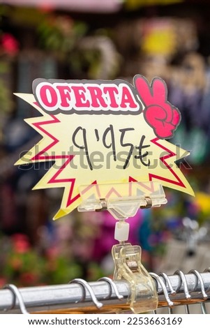Vertical closeup of price sign with the word OFERTA in Spanish (Sale in English), and the amount in Euro, or 9,95 in simple numbers. Colorful price label in a souvenir shop, tourism market, Spain.
