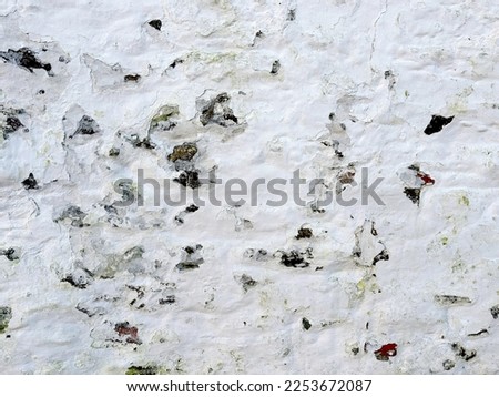 Old white cement wall shabby background. White plaster with scuffs. Scuffed on a white wall. Old white plaster wall texture.
