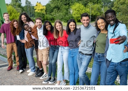 Big group of cheerful young friends taking selfie portrait, happy diverse people looking at the camera and smiling, concept of community, youth lifestyle and friendship