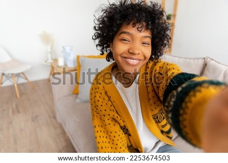 Happy african american teen girl blogger smiling face talking to webcam recording vlog. Social media influencer woman streaming making video call at home. Headshot portrait selfie webcamera view Royalty-Free Stock Photo #2253674503