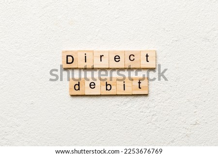 direct debit word written on wood block. direct debit text on cement table for your desing, concept.