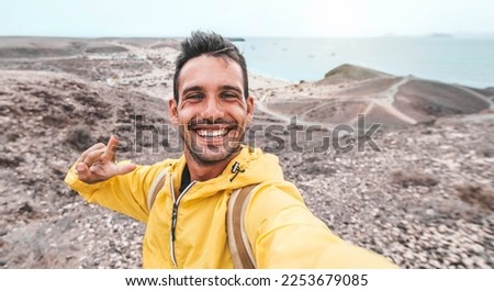 Happy young man with backpack taking selfie picture on summer vacation - Travel blogger on social media - Trip, technology and people concept