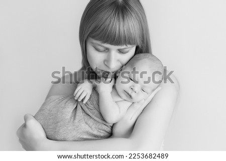 newborn baby in mom's arms, black and white photo, monochrome. parental care for a new life